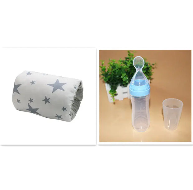 Baby bottle with blue cap and clear container next to a roll of white fabric with star patterns on a white background.
