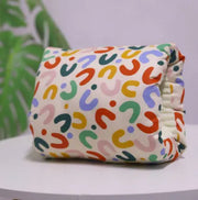 Colorful patterned diaper on a white surface with a blurred green plant in the background