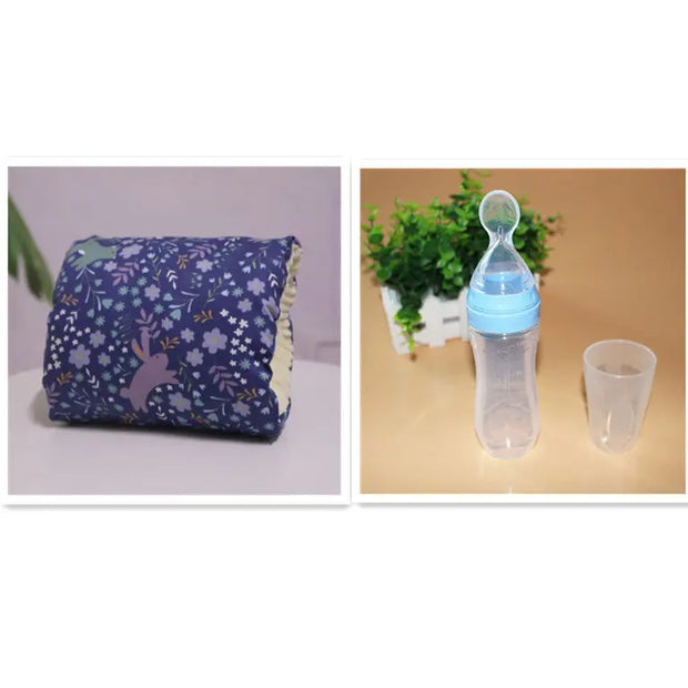 Purple baby blanket with a floral pattern and blue baby bottle on a beige surface.