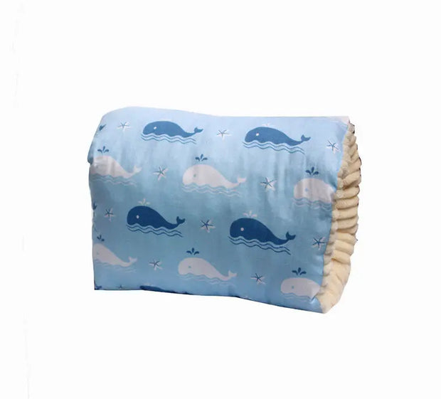 Folded blanket with whale pattern on a light blue background