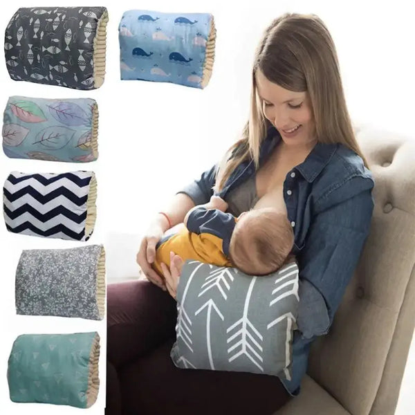 A woman breastfeeding a baby while sitting on a couch, with various patterned pillows displayed.