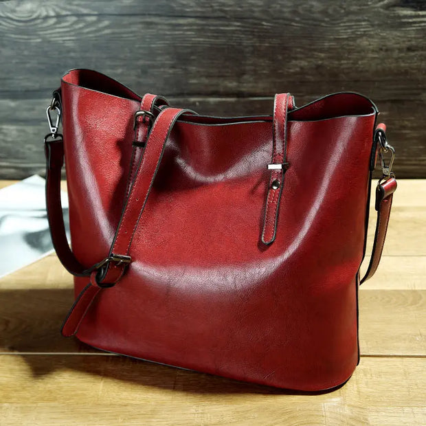 Red leather handbag on a wooden surface with a dark wood background
