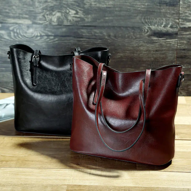 Black and brown leather handbags on a wooden surface with a wooden background