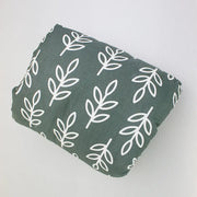 Green fabric with a white leaf pattern on a light gray background