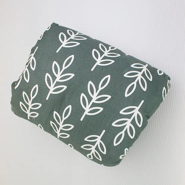 Green fabric with a white leaf pattern on a light gray background
