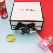 Gift box with 'Best Wishes' text, black bow, and a can of Coca-Cola on a colorful background.