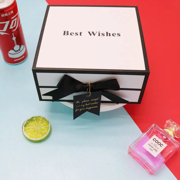 Gift box with 'Best Wishes' text, black bow, and a can of Coca-Cola on a colorful background.