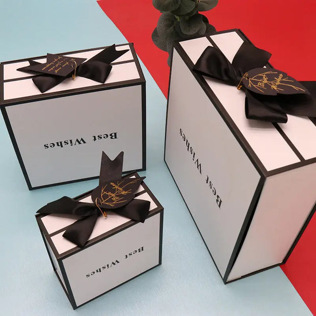 Three decorative boxes with black bows on a red and blue background