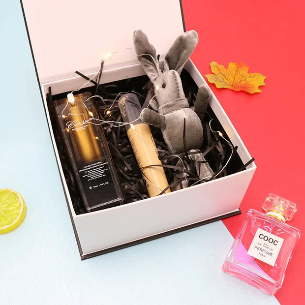 Gift box with a plush toy, bottle, and other items on a colorful background