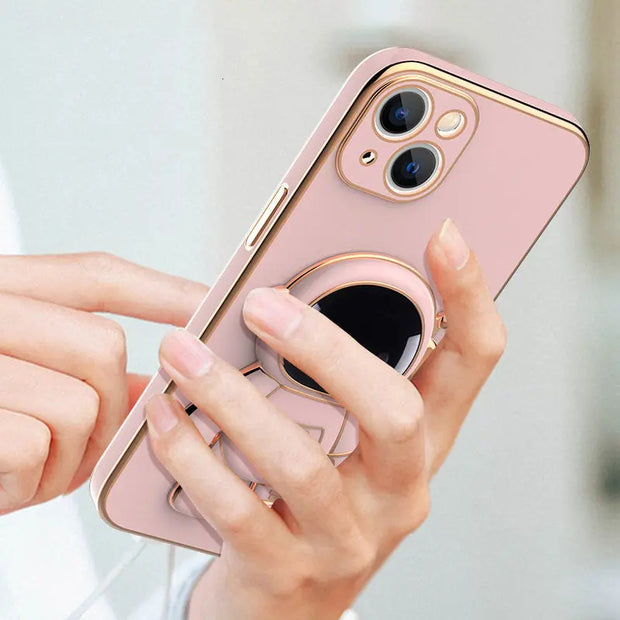 Phone case with ring holder held by a hand against a light background