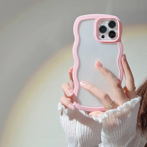 Hand holding a phone with a pink case against a neutral background