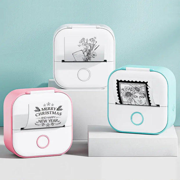Two small printers, one pink and one blue, with printed designs on a light blue background.