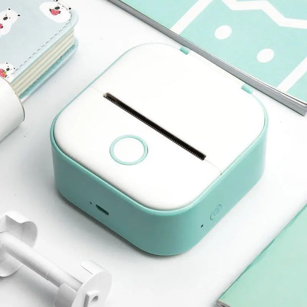 Portable Mini Thermal Label Printer Home Photo Printer Student Wrong Question Printer Bluetooth-compatible Mini Label Printer Price Tag in white and teal color on desk.