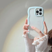Person holding a phone with a clear case against a neutral background