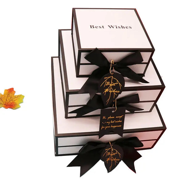 Stack of gift boxes with black ribbons and 'Best Wishes' text on a white background